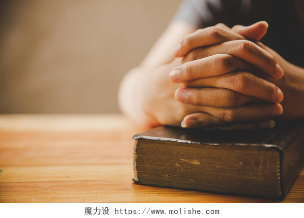 房子书本上的手在木制桌子的背景上祈祷人类的手和圣经。基督教概念。真诚希望爱情的概念.